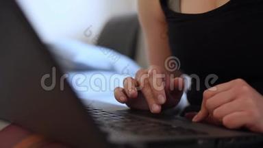 在家庭办公室工作的女人手按键盘关闭。 一个漂亮的女人坐在家里的沙发上，手提电脑，从